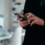 Pessoa segurando celular; imagem ilustrativa que não retrata golpe ou transação bancária. Foto: Jonas Leupe/Unsplash.