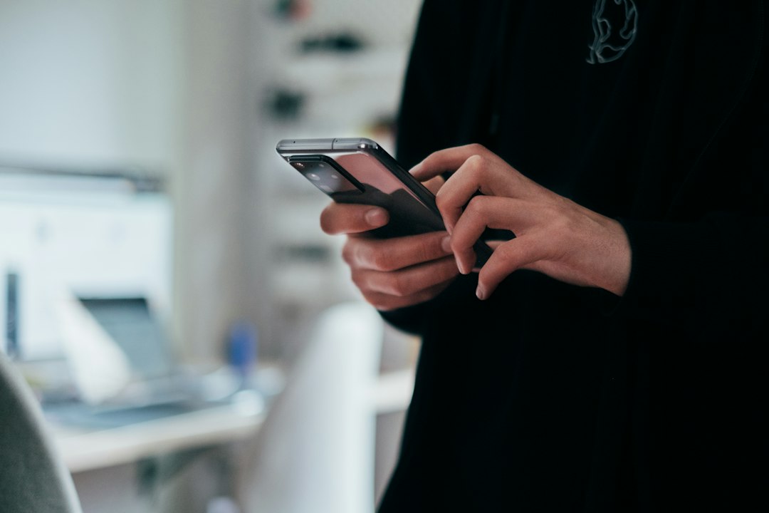 Pessoa segurando celular; imagem ilustrativa que não retrata golpe ou transação bancária. Foto: Jonas Leupe/Unsplash.